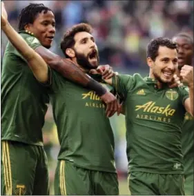  ?? PETE CHRISTOPHE­R — THE ASSOCIATED PRESS ?? Diego Valeri, center, celebrates with teammates after scoring a goal in the first half against the New England Revolution on Sunday. The Western Conference-leading Timbers visit the Union tonight as they begin a three-game homestand.