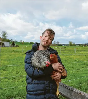  ?? Foto: Anna Mohl ?? Timo Lapperger mit zwei Hühnern auf dem Geflügelho­f seiner Familie.