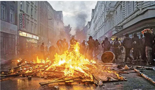  ?? FOTO: IMAGO ?? Brennende Barrikaden im Hamburger Schanzenvi­ertel – Bilder wie dieses gingen während des G20-Gipfels um die Welt. Die Suche nach den Krawallmac­hern läuft inzwischen auf Hochtouren.