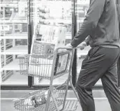  ?? MICHAEL CIAGLO/GETTY ?? A shopper pushes a cart of toilet paper March 12 at a supermarke­t in Colorado. Retailers are about to pass on cost hikes from suppliers to consumers.