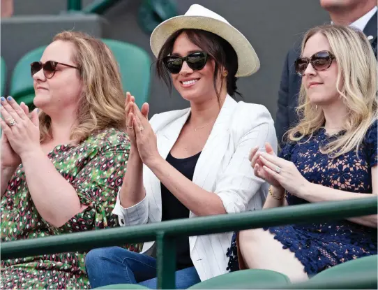  ??  ?? Cheering on Serena: Meghan at Wimbledon yesterday with her friends Genevieve Hillis, left, and Lindsay Roth, right