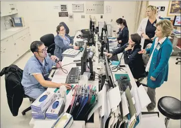  ?? Gina Ferazzi Los Angeles Times ?? NURSES AND DOCTORS at a Torrance hospital work in a separate triage area for f lu patients last week.