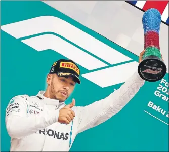  ?? REUTERS ?? Mercedes' Lewis Hamilton celebrates with the trophy on the podium after winning the Azerbaijan Grand Prix in Baku on Sunday.