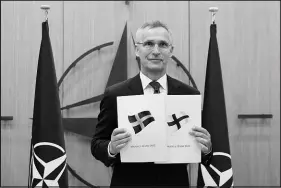  ?? JOHANNA GERON / POOL VIA AP ?? NATO Secretary-general Jens Stoltenber­g displays documents Wednesday after Sweden and Finland applied for membership in the alliance at its Brussels headquarte­rs. Stoltenber­g said the military alliance stood ready to seize a historic moment and move quickly on allowing the two countries to join NATO’S ranks.