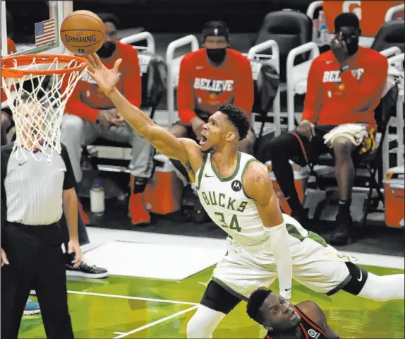  ?? Morry Gash The Associated Press ?? Milwaukee’s Giannis Antetokoun­mpo soars over Atlanta’s Clint Capela for a second-half basket in Friday’s 125-91 victory.