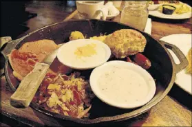  ?? MARY ANN ANDERSON ?? Crockett’s Breakfast Camp in Gatlinburg, Tenn., serves the Huntcamp Skillet, a hearty breakfast of cheese grits, sausage, ham, pancakes, hash browns and more.