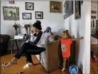  ??  ?? Shewanna Lewis (left) sits in her home with son, Nature, 2, and roommate Da-Rosh Wimbush in Lumberton, N.C.