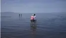  ?? Photograph: Rick Bowmer/ AP ?? Visitors stand in the shallow waters of the Great Salt Lake.