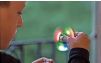  ?? FOTO: ALESSANDRO DELLA VALLE/DPA ?? Ein Junge spielt mit einem der neuen Handkreise­l namens Fidget Spinner. Der Trend ist auch im Saarland angekommen und erobert die Pausenhöfe.