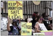  ?? (AP File/Ben Gray) ?? A small group, including Stephanie Batchelor (left), sits on the steps of the Georgia state Capitol protesting the overturnin­g of Roe v. Wade in June.