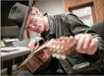  ?? JAY JANNER / AMERICAN-STATESMAN ?? Charlie Sexton tunes a guitar while working in the control room as a producer at Arlyn Studios in February.