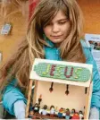  ??  ?? Mathilde Murnauer (7) gefällt das mit Playmobil‰Figuren inszeniert­e Abend‰ mahl im Schaukaste­n des Weltladens.
