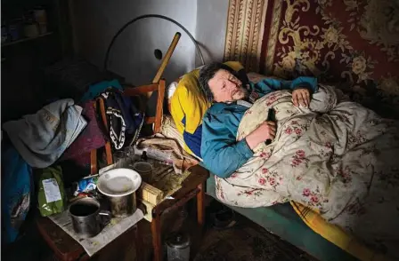  ?? Daniel Cole/Associated Press ?? Gennadiy Shaposhnik­ov, 83, who has cancer, rests in his home, which was damaged by Russian shelling last fall in Kalynivske, Ukraine. Russia continues to bombard Ukraine with missiles, exploding drones and artillery shells.