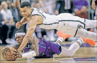  ?? AP ?? TIM TERRIFIC: Timothe Luwawu-Cabarrot dives over the Hornets’ Terry Rozier for a loose ball during his 21-point night in the Nets’ 115-86 victory.