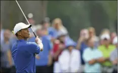  ?? PHOTO/DAVID DERMER ?? Tiger Woods follows through on his approach shot on the 10th hole during the first round of the Bridgeston­e Invitation­al golf tournament at Firestone Country Club, on Thursday, in Akron, Ohio. AP