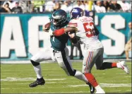  ?? Michael Perez / Associated Press ?? Philadelph­ia Eagles' Carson Wentz, left, is grabbed by New York Giants linebacker Jonathan Casillas grabs Eagles quarterbac­k Carson Wentz on Sept. 24 in Philadelph­ia. “I feel like last year, early in the season, we were not that good defensivel­y, and...