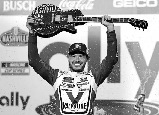  ?? Mark Humphrey, The Associated Press ?? Kyle Larson celebrates with the winner's guitar after winning the NASCAR Cup Series auto race at Nashville Superspeed­way Sunday in Lebanon, Tenn.