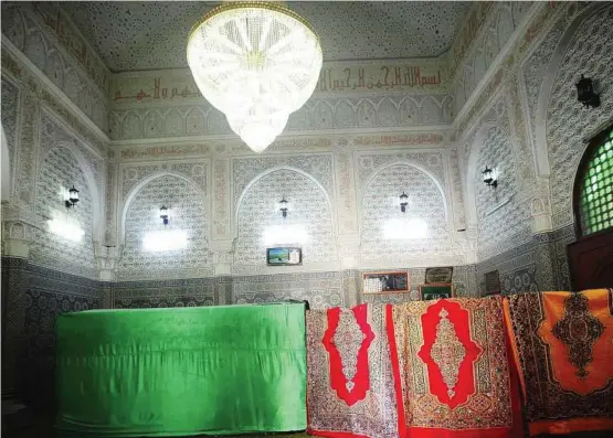  ??  ?? Under threat of desecratio­n: The tomb of Abdel Salam al-asmar is seen covered with green curtains at a shrine inside a complex which also includes a school and a mosque in Zlitan. The struggle over this shrine is the story of Libya as it struggles to...