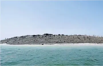  ?? AFP ?? LEFT Pakistani men walk on an island that appeared 2km off the coastline of Gwadar yesterday, after an earthquake the day before. The National Institute of Oceanograp­hy has sent a team to survey the island, which stands about 20 metres high.