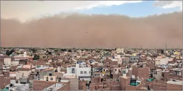  ??  ?? A dust storm approaches the city of Bikaner on Wednesday. The storm barrelled through a swathe of Rajasthan and UP, killing at least 106.