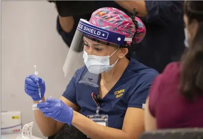  ?? PHOTOS BY WAYNE TILCOCK — UC DAVIS HEALTH ?? Registered Nurse Reanne Takara administer­s vaccine shots at UC Davis Medical Center, on Tuesday.