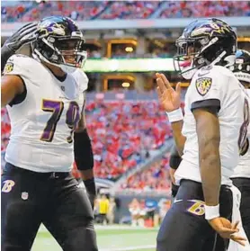  ?? KEVIN C. COX/GETTY ?? Ravens quarterbac­k Lamar Jackson, right, celebrates rushing for a touchdown against the Falcons with left tackle Ronnie Stanley on Dec 2, 2018 in Atlanta.