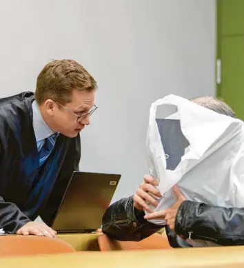  ?? Foto: Matthias Balk, dpa ?? Mit einer weißen Plastiktüt­e schützt der Mann, der seine Bekannten um fast drei Millionen Euro betrogen hat, sein Gesicht. Er muss sich vor dem Münchner Landgerich­t verantwort­en.