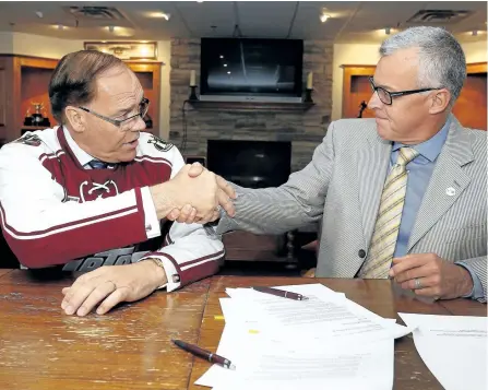  ?? CLIFFORD SKARSTEDT/EXAMINER FILES ?? Peterborou­gh Mayor Daryl Bennett and Peterborou­gh Petes president Dave Pogue sign the amended facility agreement between the City of Peterborou­gh and the Petes in the Pat Casey Alumni Room on Aug. 11 at the Memorial Centre. Pogue tells The Examiner...