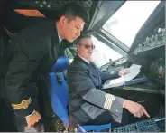  ?? YIN LIQIN / FOR CHINA DAILY ?? Paul Emerson Sommerfeld, a flight captain from the United States employed by China Eastern Airlines, talks with a Chinese colleague in 2016.