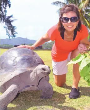  ?? STEVE MACNAULL PHOTO ?? Tyson the 120-year-old tortoise hangs out with Kerry MacNaull on Curieuse island in the Seychelles.