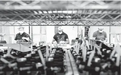  ?? CARLOS OSORIO AP ?? Ford line workers assemble ventilator­s in Michigan. Industrial production was helped by a rebound in output at auto plants.