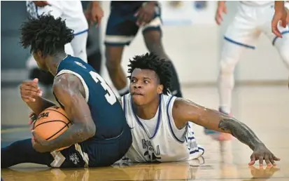  ?? KENNETH K. LAM/BALTIMORE SUN ?? Mount Saint Joseph’s Amani Hansberry, right, gets called for a foul as he battles with Goretti’s Jahsan Johnson in the fourth quarter.