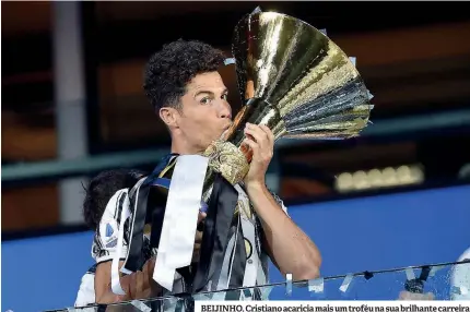  ??  ?? BEIJINHO. Cristiano acaricia mais um troféu na sua brilhante carreira