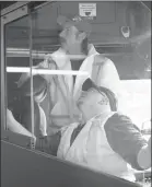  ?? BC TRANSIT/Special to The Daily Courier ?? B.C. Transit workers install vinyl shields on a bus.The shields are temporary until full doors arrive.