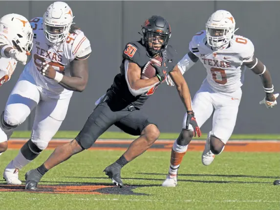  ?? Sue Ogrocki, The Associated Press ?? Oklahoma State running back Chuba Hubbard (30) led FBS with 2,094 rush yards in 2019, but after a disappoint­ing 2020 he could fall into the later rounds of the NFL Draft.