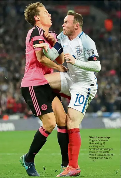  ??  ?? Watch your step: England’s Wayne Rooney (right) colliding with Scotland’s Christophe Berra in the 2018 World Cup qualifier at Wembley on Nov 11. — AP