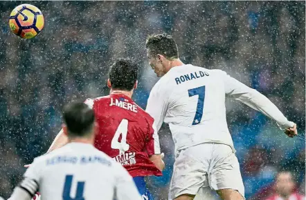  ??  ?? Up and away: Real Madrid’s Cristiano Ronaldo (right) heads past Sporting Gijon’s Jorge Mere during the La Liga match at the Bernabeu on Saturday. — AFP