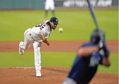  ?? AP Photo/David J. Phillip ?? ■ Houston Astros starting pitcher Lance McCullers Jr., left, throws to Seattle Mariners’ Evan White during the first inning of a baseball game Saturday in Houston.