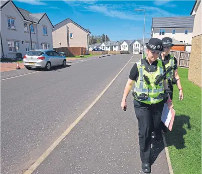  ?? Picture: Phil Hannah. ?? Police officers conduct door-to-door inquiries in Auchterard­er after the death.