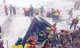  ?? SOURCE: NATIONAL ALPINE CLIFF AND CAVE RESCUE CORPS ?? In this photo released Sunday, rescuers work in the area of the avalanche-hit Rigopiano hotel in central Italy. After two days huddled in freezing cold, tons of snow surroundin­g them, survivors greeted their rescuers Friday as “angels.”