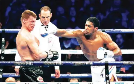  ?? AFP ?? Anthony Joshua lands a punch that knocks Alexander Povetkin to the canvas in the seventh round of their world heavyweigh­t title fight at Wembley Stadium in northwest London on Saturday night.