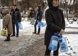  ?? ?? People wait Saturday for a turn to refill their water jugs with drinking water in Kyiv. Russia’s targeting of civilian infrastruc­ture also has stripped much of Ukraine of power and heat.