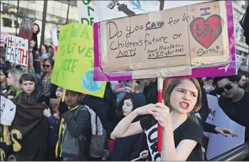  ?? Justin Sullivan Getty Images ?? STUDENTS CARRY signs as they march during the Youth Climate Strike on March 15, 2019, in San Francisco. Hundreds of thousands of students in more than 100 countries walked out of class that day.