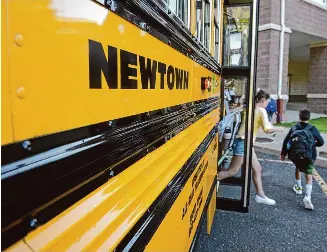  ?? H John Voorhees III/Hearst Connecticu­t Media file photo ?? Students get off the school bus for their first day of school at Reed Intermedia­te School in Newtown in 2019.