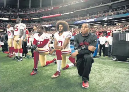  ?? GETTY ?? Eli Harold (58), Colin Kaepernick (7) and Eric Reid of San Francisco 49ers kneel to protest during the US national anthem ahead of a match in Atlanta in Dec, 2016.