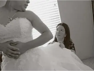  ?? Elizabeth Conley / Houston Chronicle ?? Monica Narvaez helps Marcela Trejo, of Houston, with her wedding dress. Narvaez took 30-plus dresses from Alfred Angelo’s three Houston stores before they shut down with a day’s notice.