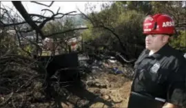  ?? DAMIAN DOVARGANES — THE ASSOCIATED PRESS ?? Los Angeles Fire Department Fire Arson Counter-Terrorism investigat­or Angel Alvarez checks a burned out homeless camp after a brush fire erupted in hills in Elysian Park in Los Angeles Thursday. The National Weather Service said extreme fire danger...