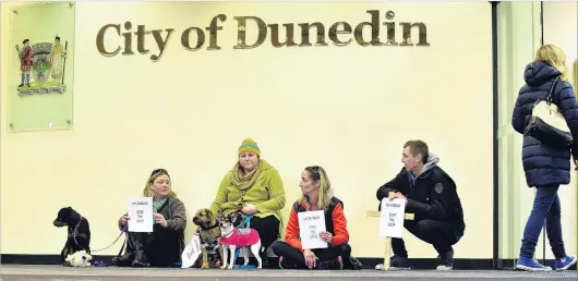  ?? PHOTO: PETER MCINTOSH ?? Fourlegged protest . . . Anti1080 protesters (from left) Michelle Hager with Bree, Samantha Luzzi with Rufus (left) and Maggie, Josie Harris and Marc Thomlinson, all of Dunedin, protest a 1080 drop set to fall on an 8600ha block in Dunedin at the...