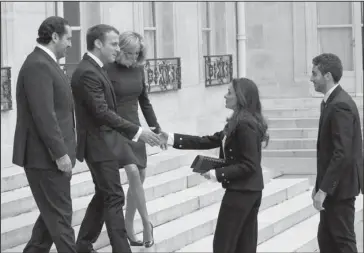  ?? The Associated Press ?? LEBANON: French President Emmanuel Macron, second left, and his wife Brigitte, centre left, greet Lebanon’s Prime Minister Saad Hariri, left, his wife Lara, center center and their son Hussam, right, upon their arrival Saturday at the Elysee Palace in...