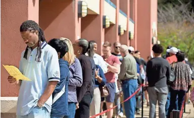  ?? JESSICA MCGOWAN/GETTY IMAGES ?? Voters wait in line for up to two hours for early voting at the Cobb County West Park Government Center in Marietta, Ga., near Atlanta, on Oct. 18. Lines could be even worse Tuesday.